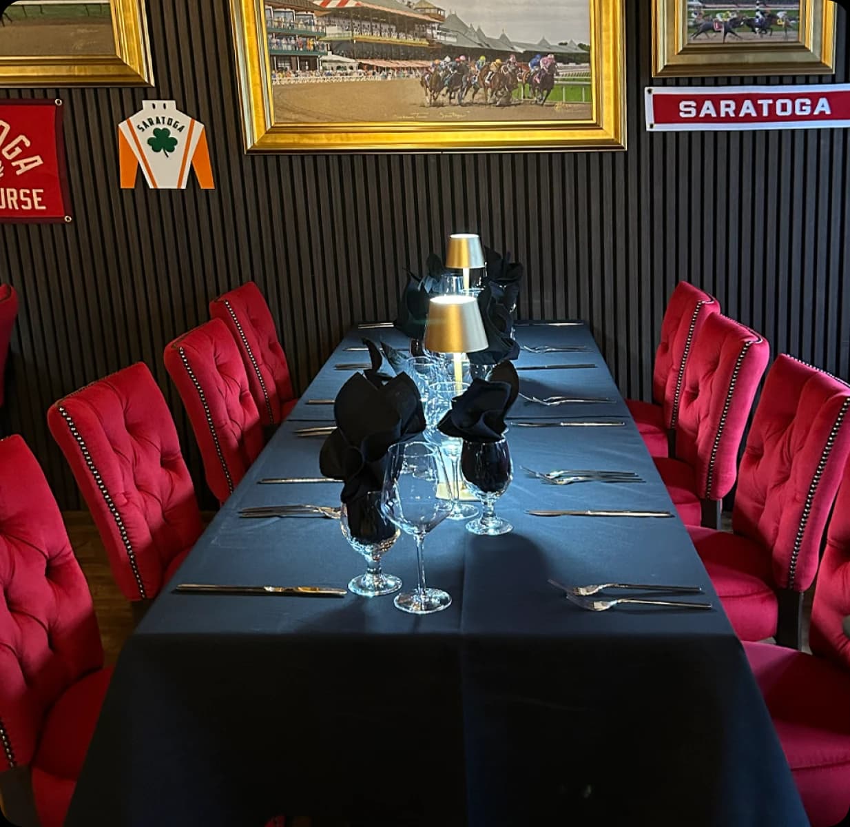 Private dining table set with red velvet chairs, Saratoga horse racing memorabilia on the walls