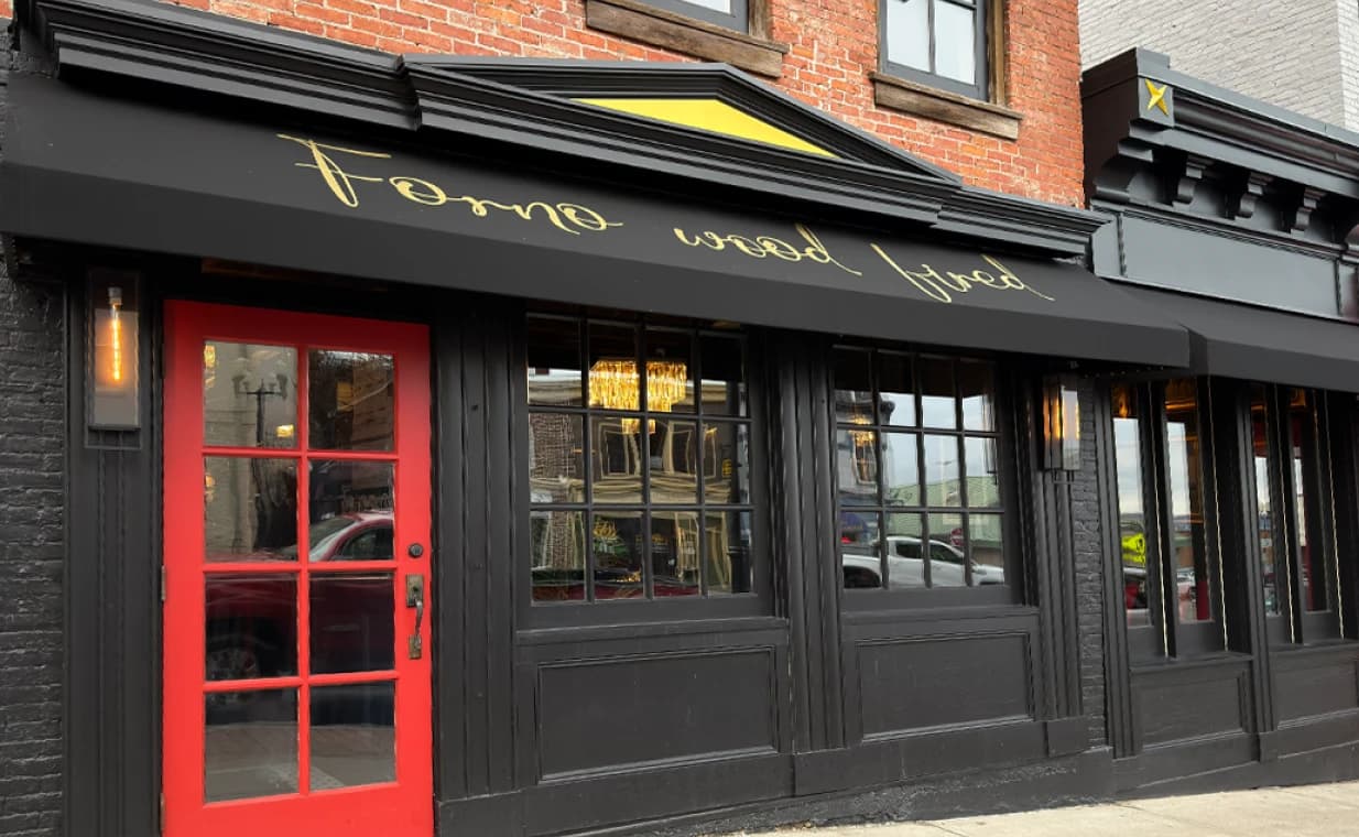 Forno Wood Fired storefront with red door, black awning, and gold script lettering